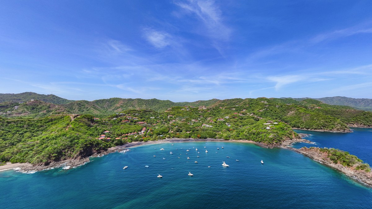 Vue aérienne d'une baie du Guanacaste sur la côte pacifique du Costa Rica, avec des voiliers ancrés dans une eau turquoise au pied de collines boisées