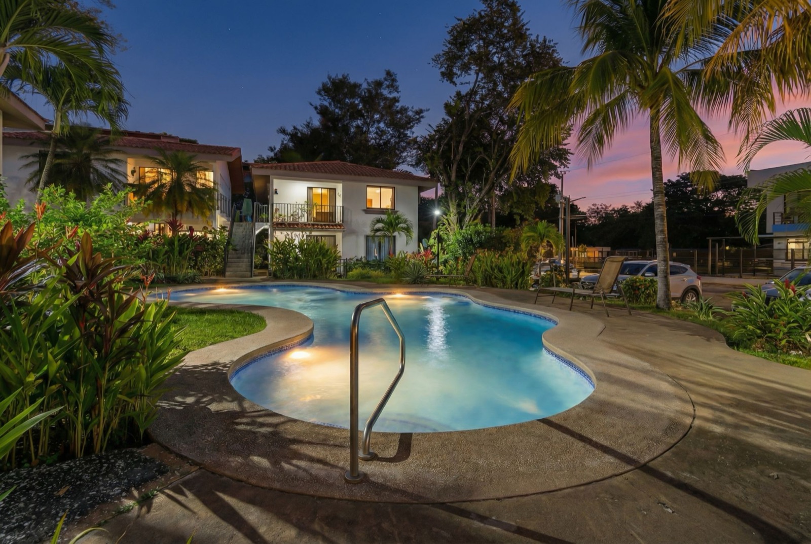 Twilight view of the community pool at Villas Las Bromelias