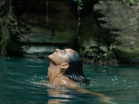 Person swimming at a waterfall pool near Rincón de la Vieja