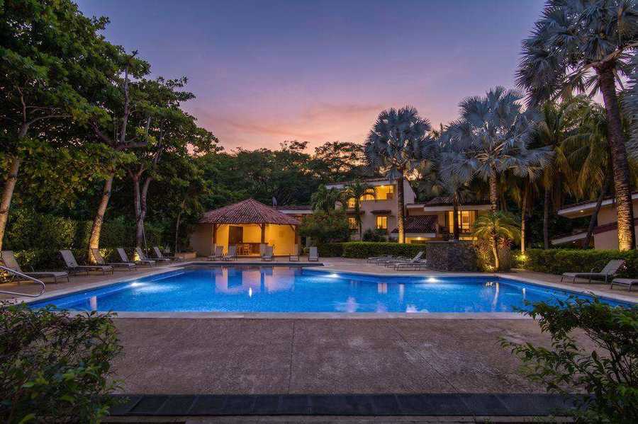 Photo au crépuscule d'une piscine et d'une villa